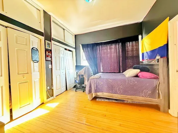 a bedroom with a bed and large windows