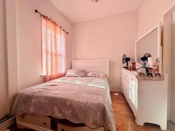 a bedroom with a bed and a large mirror on the dresser