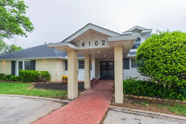 a view of a patio with table and chairs potted plants and large tree