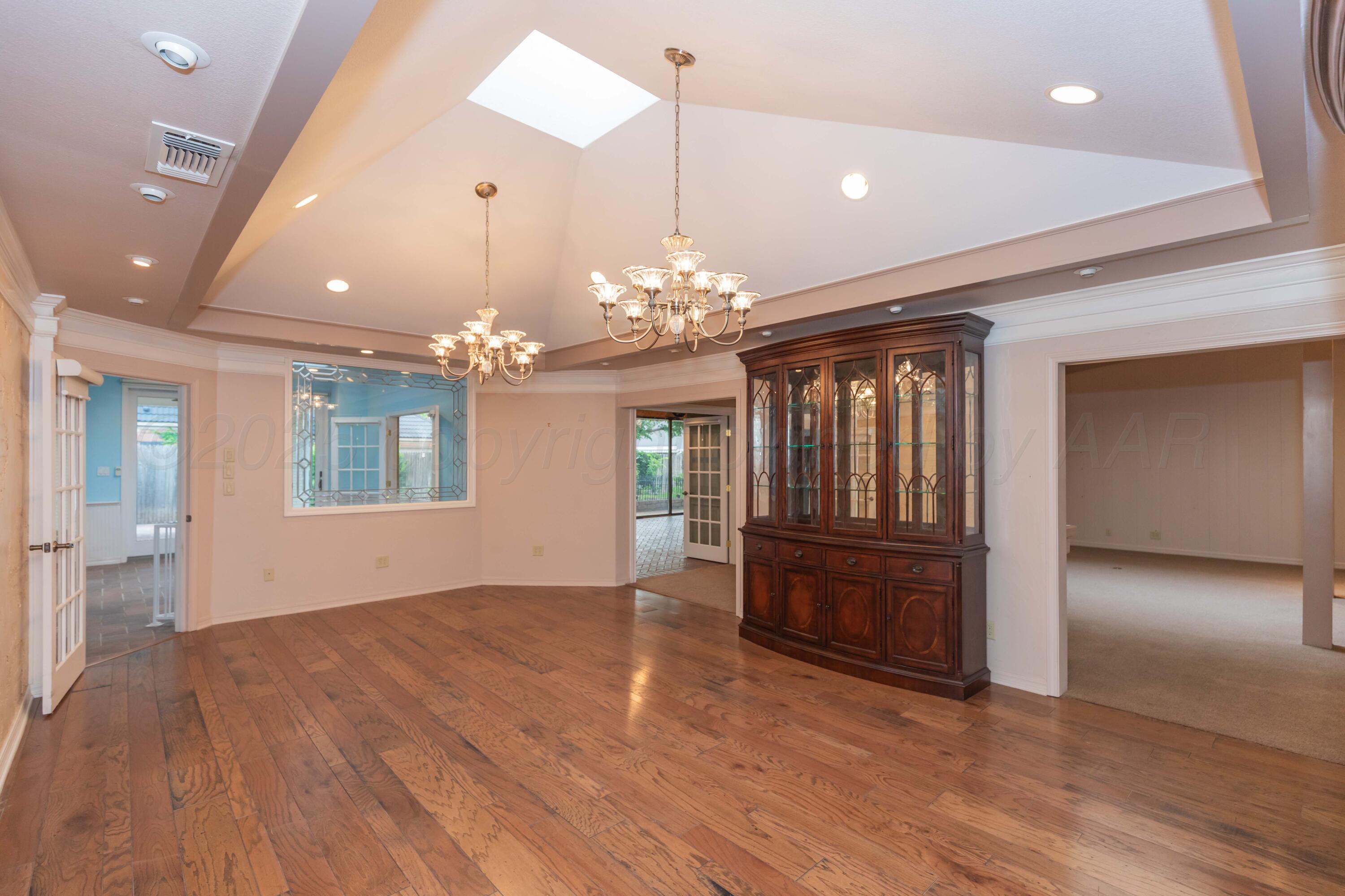 4102 Paramount Boulevard Amarillo, TX 79109 - Photo 42 of 73 an empty room with wooden floor chandelier and windows