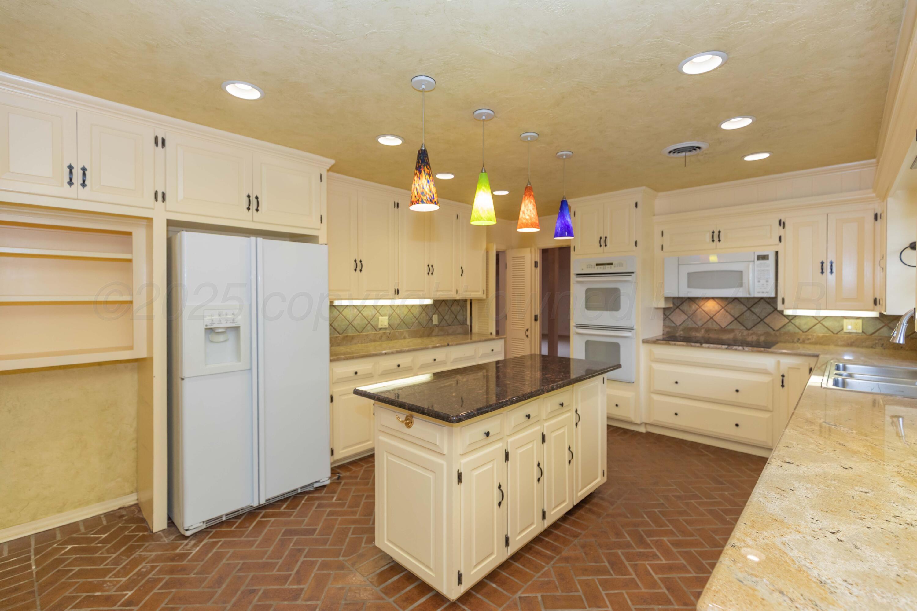 4102 Paramount Boulevard Amarillo, TX 79109 - Photo 46 of 73 a kitchen with stainless steel appliances kitchen island granite countertop a refrigerator and a stove top oven