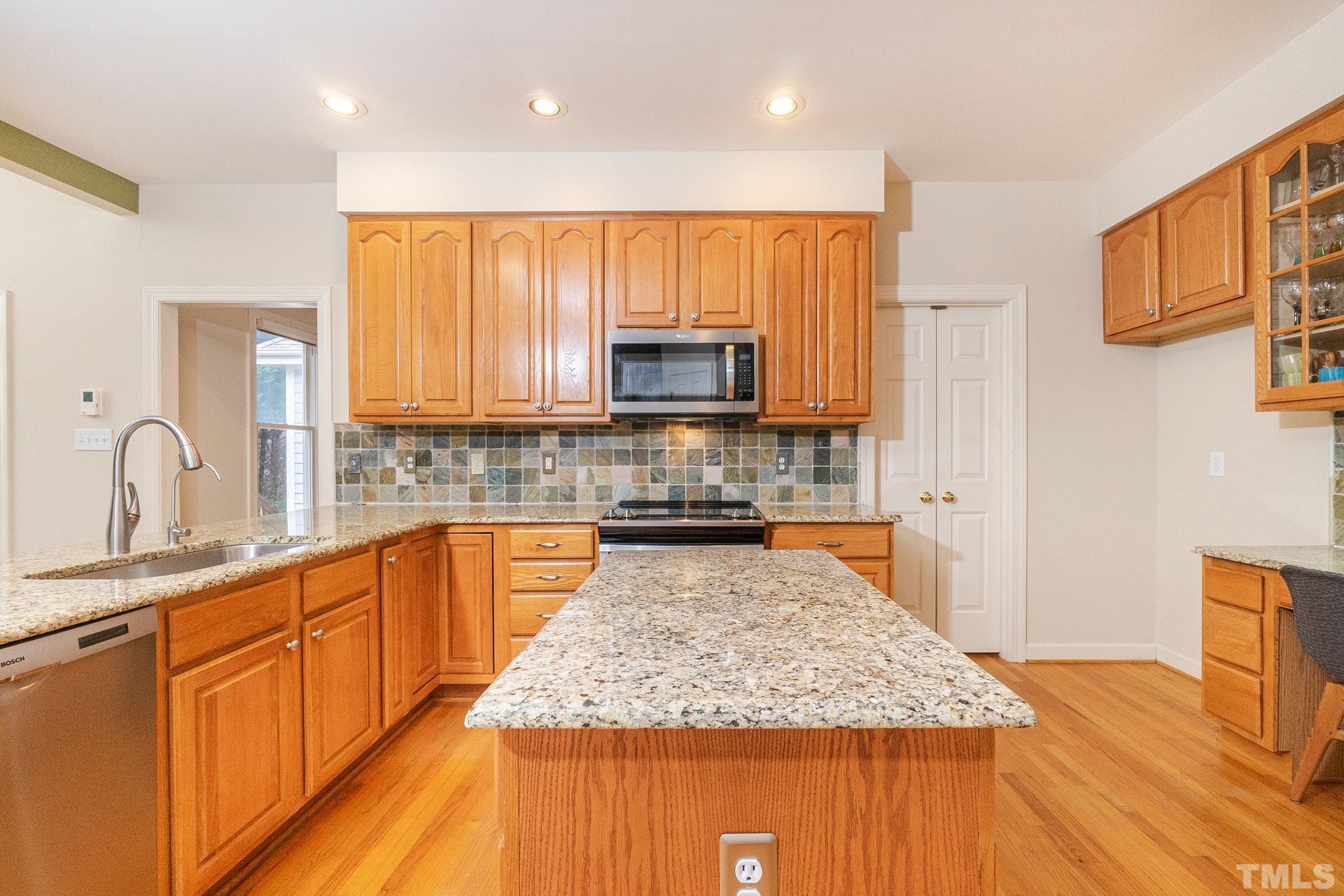 6316 Ashley Ridge Drive Raleigh, NC 27612 - Photo 11 of 45 a kitchen with stainless steel appliances granite countertop a stove a sink and a microwave