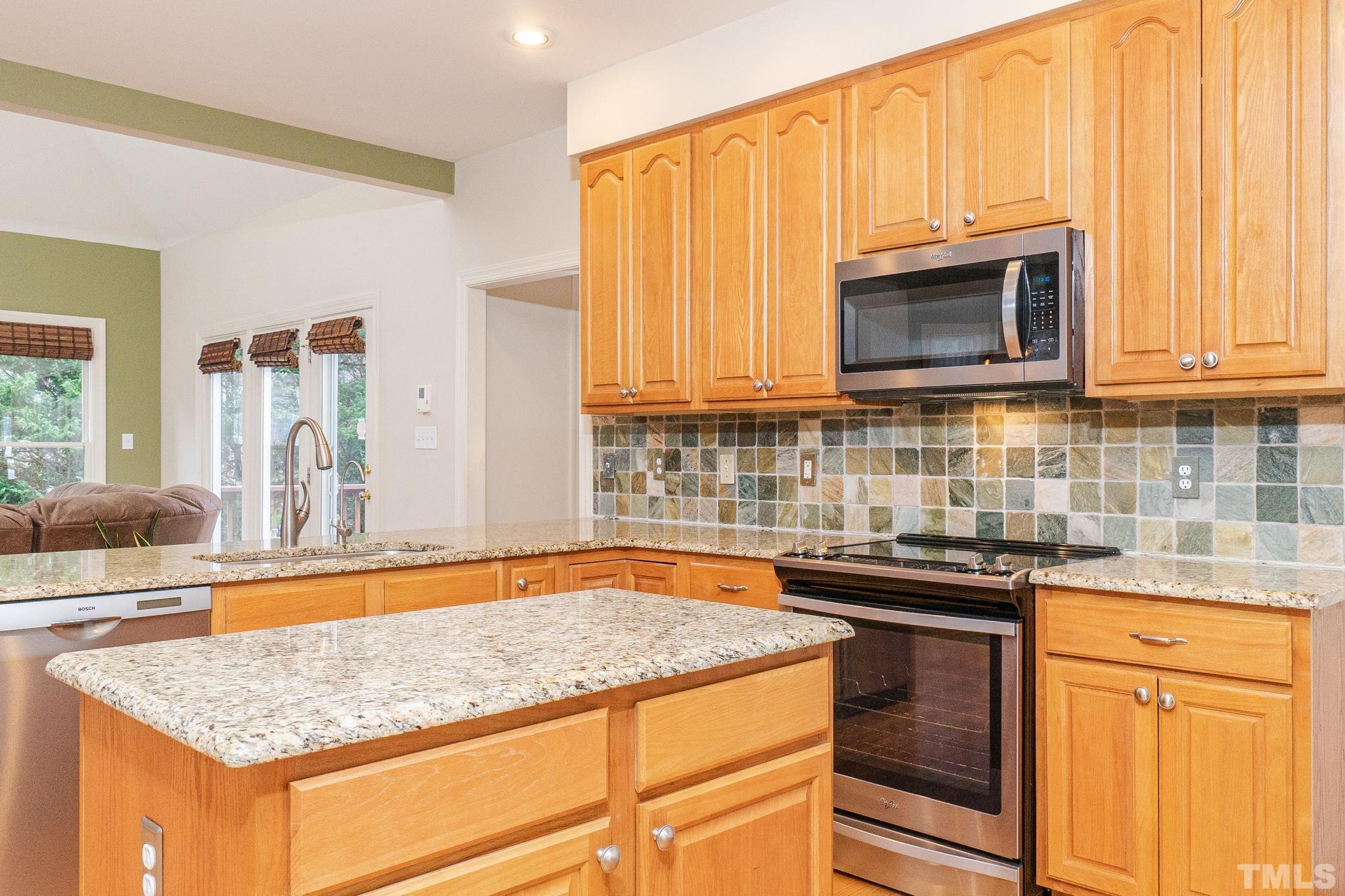 6316 Ashley Ridge Drive Raleigh, NC 27612 - Photo 12 of 45 a kitchen with stainless steel appliances granite countertop a sink stove and microwave