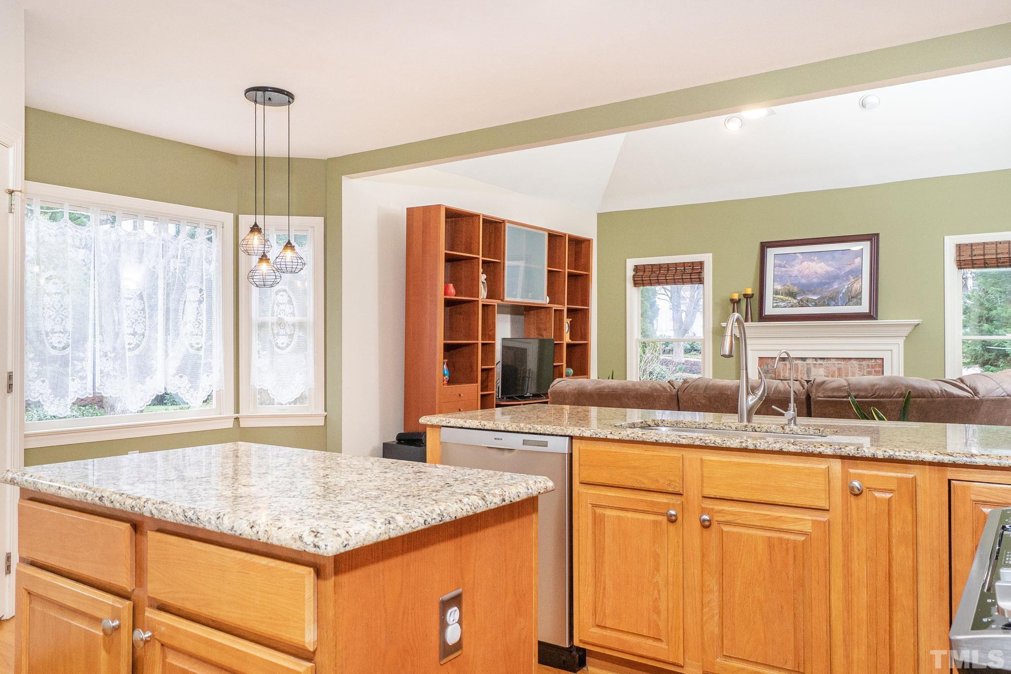6316 Ashley Ridge Drive Raleigh, NC 27612 - Photo 14 of 45 a kitchen with granite countertop kitchen island wooden cabinets a counter top space and stainless steel appliances