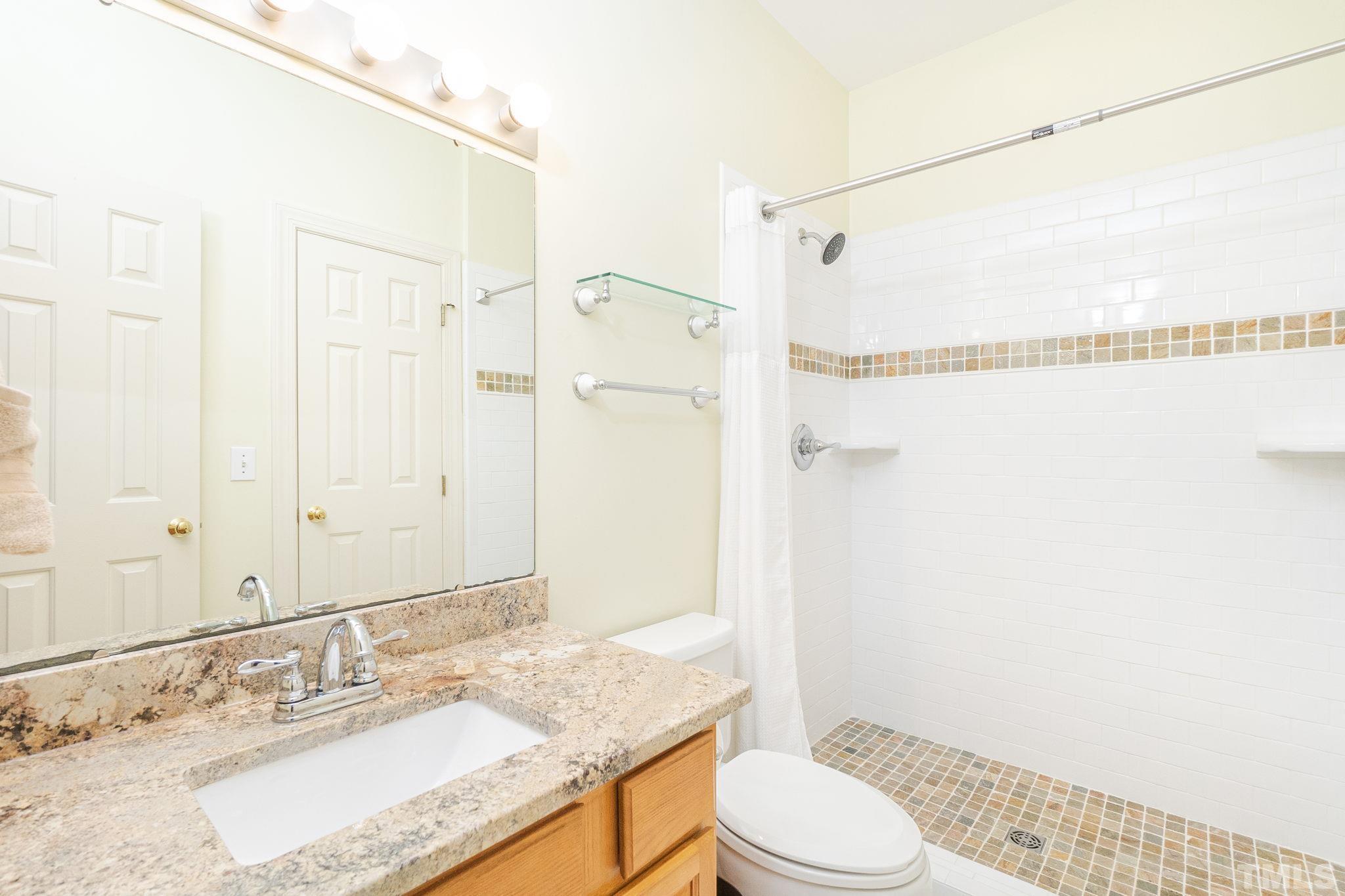6316 Ashley Ridge Drive Raleigh, NC 27612 - Photo 25 of 45 a bathroom with a granite countertop sink toilet and shower