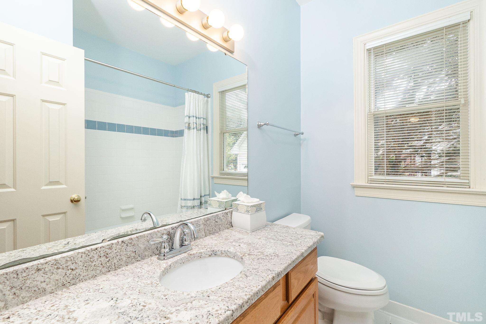 6316 Ashley Ridge Drive Raleigh, NC 27612 - Photo 27 of 45 a bathroom with a granite countertop sink a mirror and a toilet