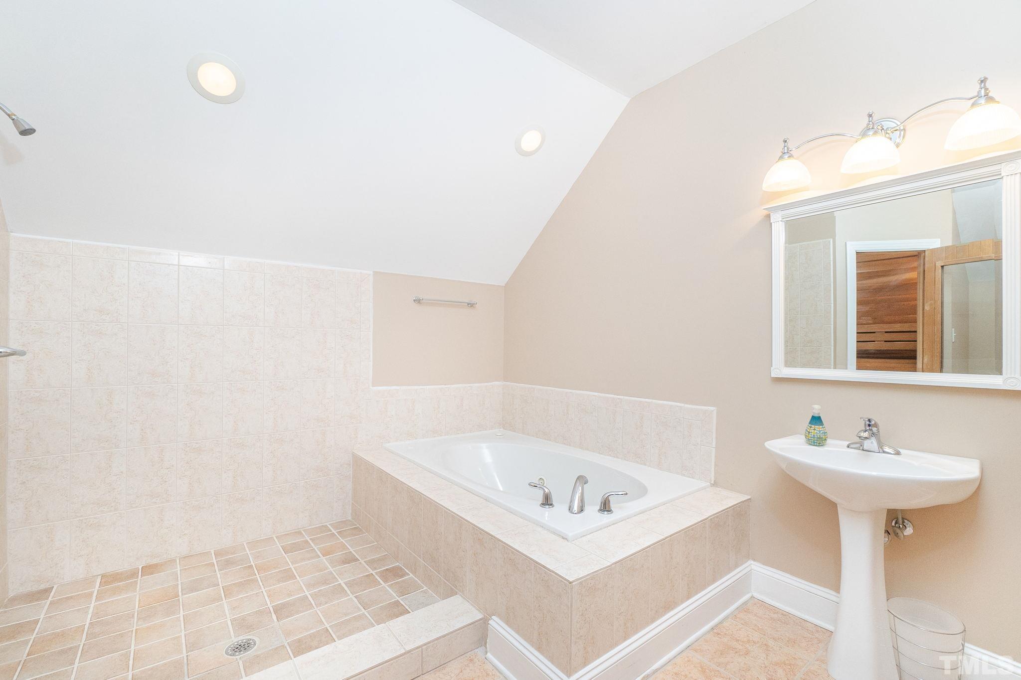 6316 Ashley Ridge Drive Raleigh, NC 27612 - Photo 30 of 45 a bathroom with a sink a mirror and a shower