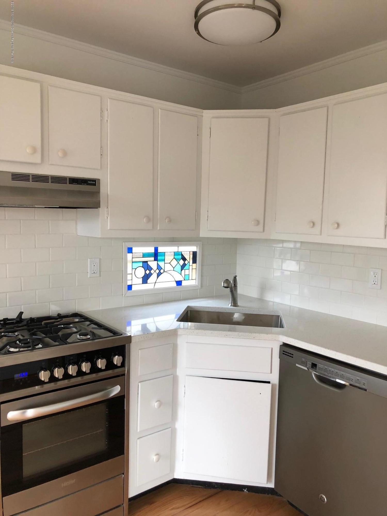 632 Main Avenue, Unit 5 Point Pleasant Beach, NJ 08742 - Photo 4 of 16 a kitchen with granite countertop white cabinets and white appliances
