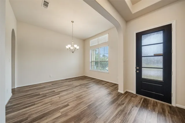 a large white kitchen with a white countertops a stove and a wooden floor