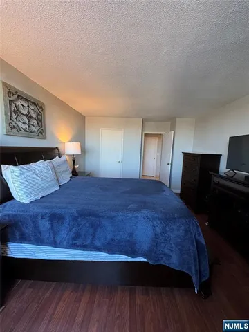 a spacious bedroom with a bed and wooden floor