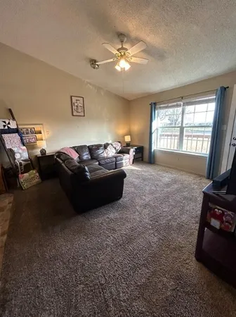 a living room with furniture a chandelier and a window
