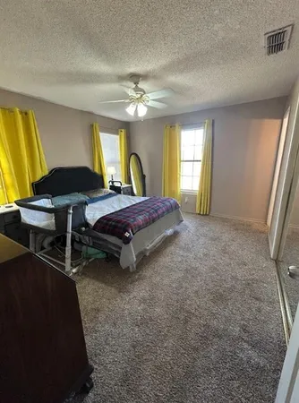 a spacious bedroom with a bed and a chandelier