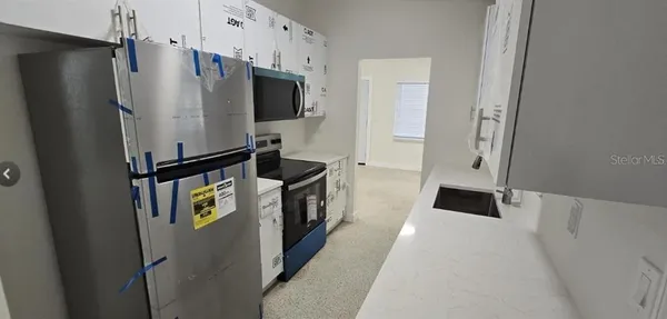 a kitchen with stainless steel appliances a refrigerator and a stove top oven