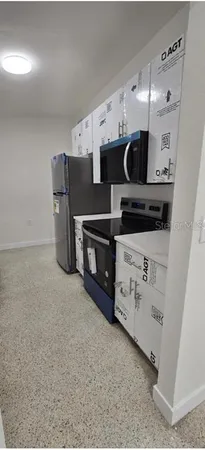 a kitchen with stainless steel appliances a stove refrigerator and cabinets