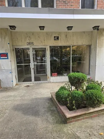 a view of a house with a potted plant in front of door