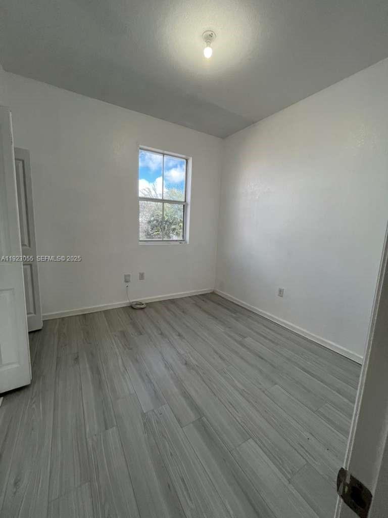 11665 Southwest 244 Street, Unit 116 Homestead, FL 33032 - Photo 14 of 32 an empty room with wooden floor and windows