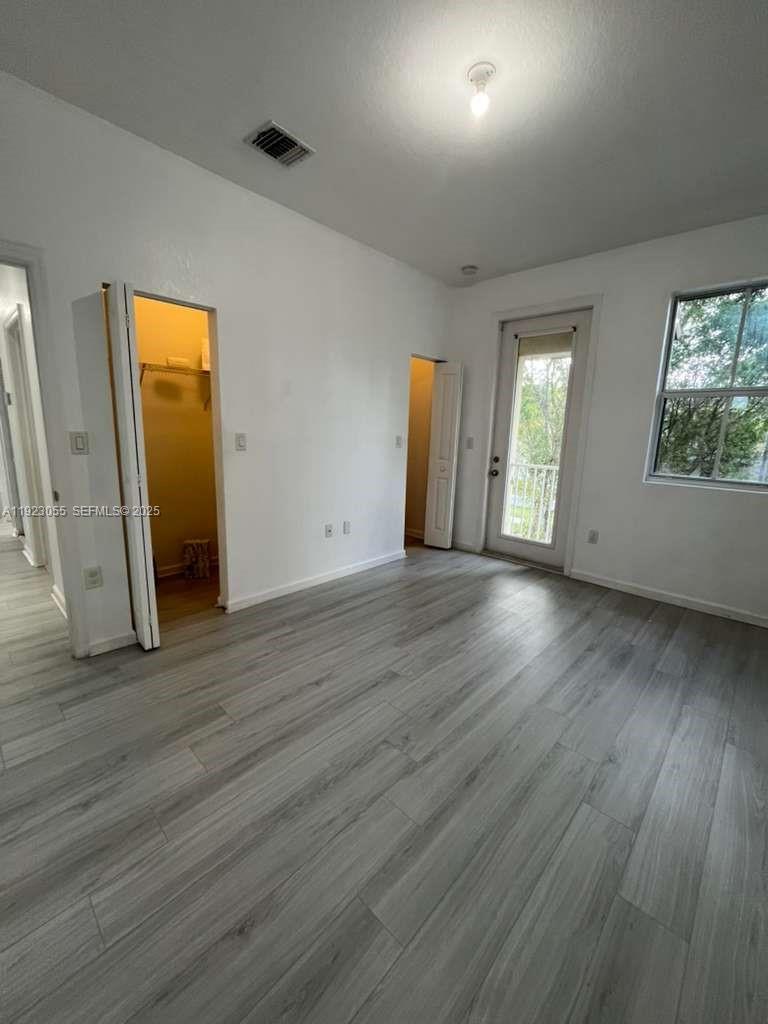 11665 Southwest 244 Street, Unit 116 Homestead, FL 33032 - Photo 19 of 32 an empty room with wooden floor and windows