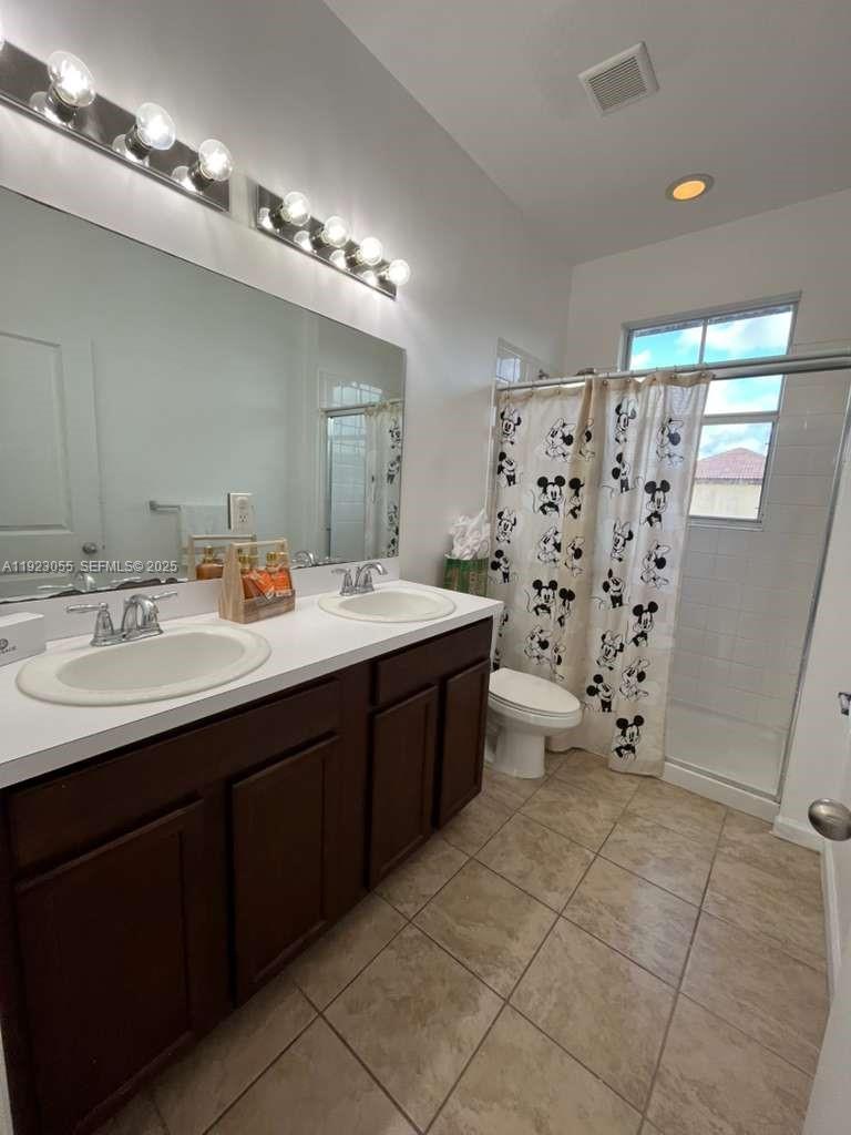 11665 Southwest 244 Street, Unit 116 Homestead, FL 33032 - Photo 20 of 32 a bathroom with a double vanity sink mirror and toilet