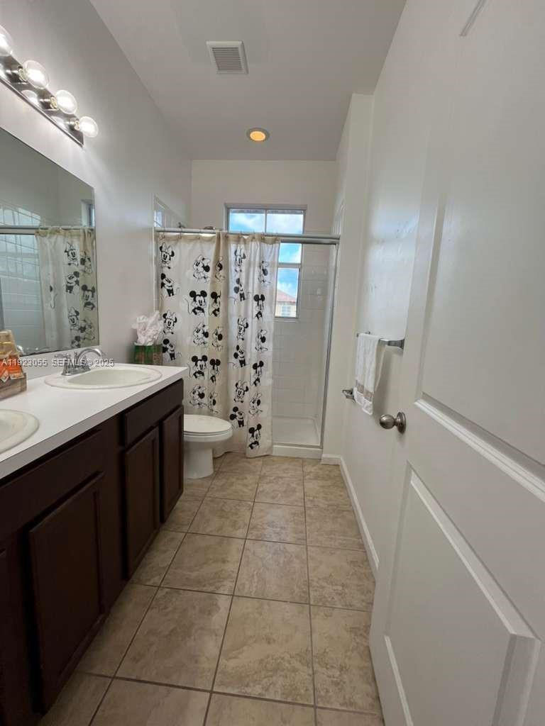 11665 Southwest 244 Street, Unit 116 Homestead, FL 33032 - Photo 21 of 32 a spacious bathroom with a double vanity sink a mirror and a shower