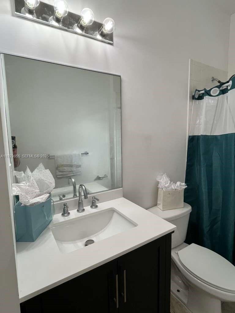 11665 Southwest 244 Street, Unit 116 Homestead, FL 33032 - Photo 25 of 32 a bathroom with a sink vanity mirror and toilet