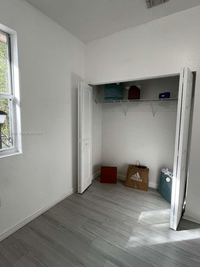 11665 Southwest 244 Street, Unit 116 Homestead, FL 33032 - Photo 30 of 32 a view of empty room with wooden floor and window