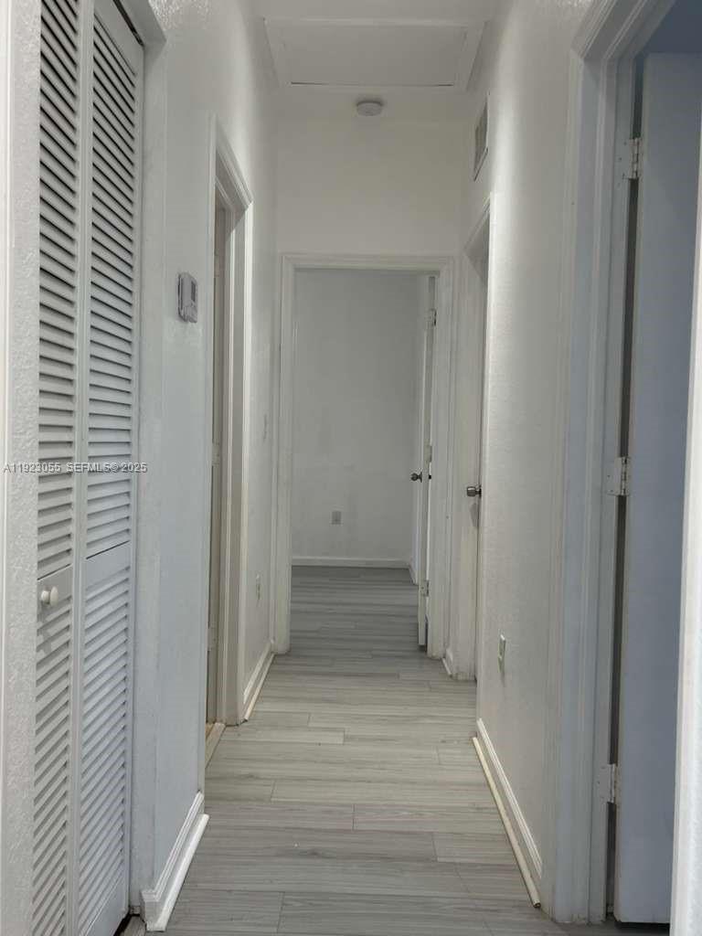 11665 Southwest 244 Street, Unit 116 Homestead, FL 33032 - Photo 31 of 32 a view of a hallway with wooden floor