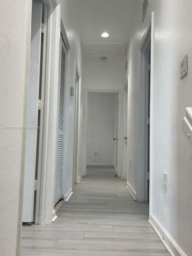 11665 Southwest 244 Street, Unit 116 Homestead, FL 33032 - Photo 32 of 32 a view of a hallway with wooden floor and a bathroom