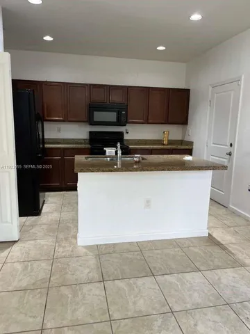 a kitchen with stainless steel appliances a stove a sink a counter top space and cabinets