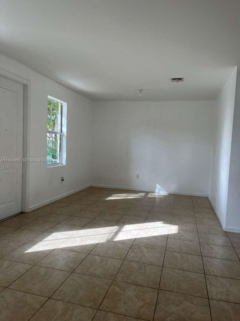11665 Southwest 244 Street, Unit 116 Homestead, FL 33032 - Photo 6 of 32 an empty room with a empty space and window
