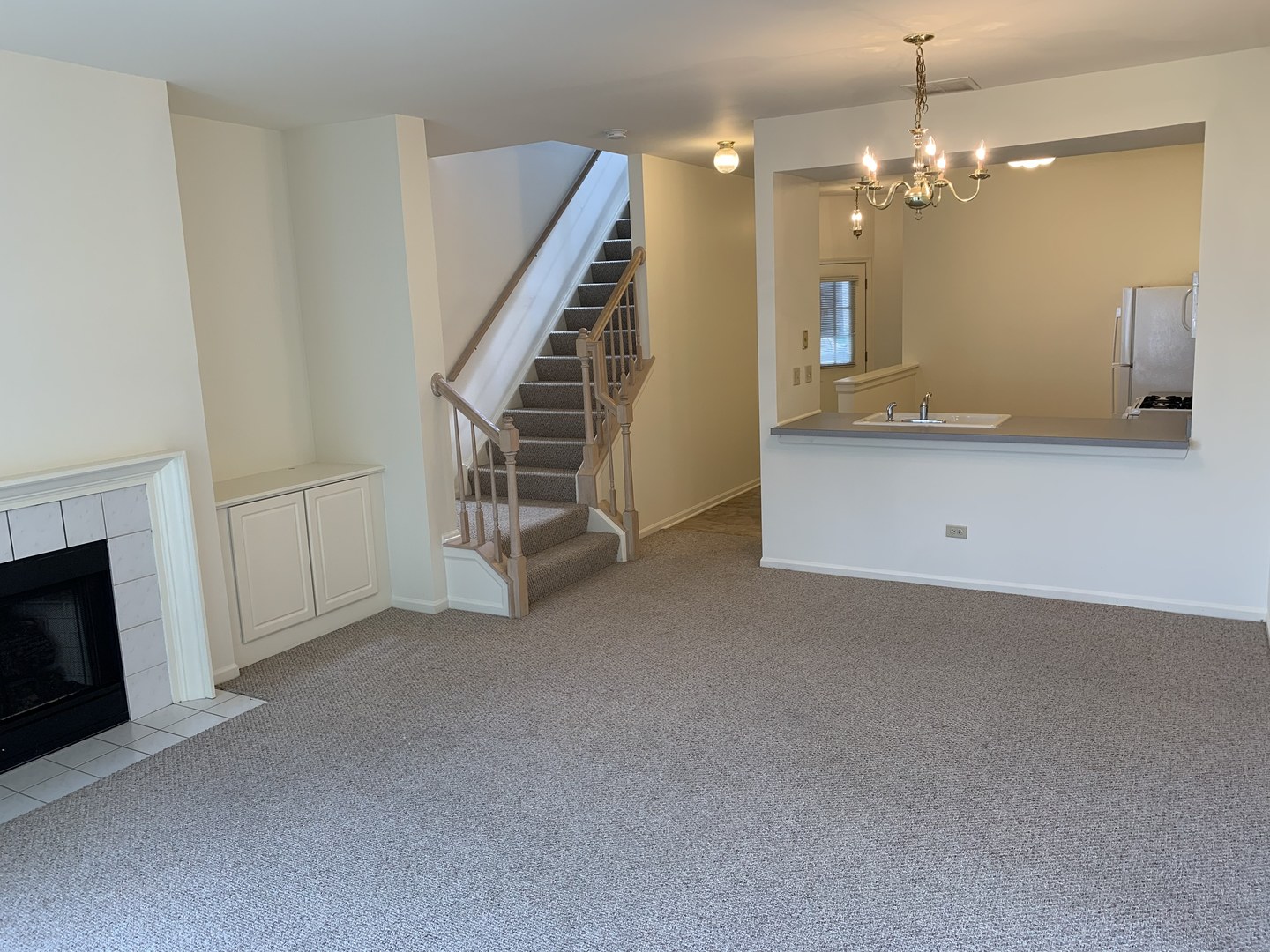 17888 Braewick Road Gurnee, IL 60031 - Photo 11 of 16 a view of a livingroom with a fireplace a chandelier and stairs