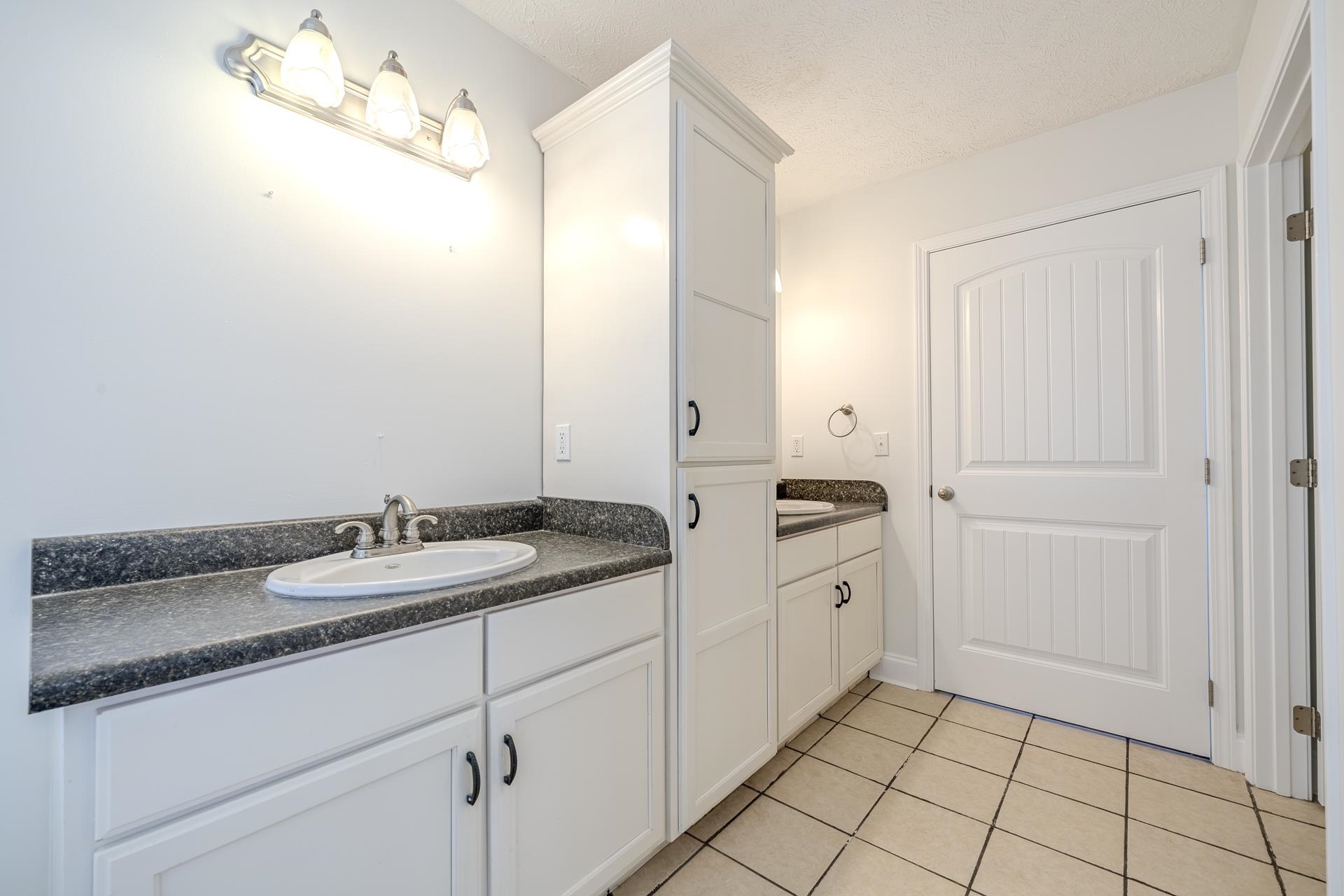 200 Boyd Road Adamsville, TN 38310 - Photo 14 of 26 a spacious bathroom with a granite countertop sink and a mirror