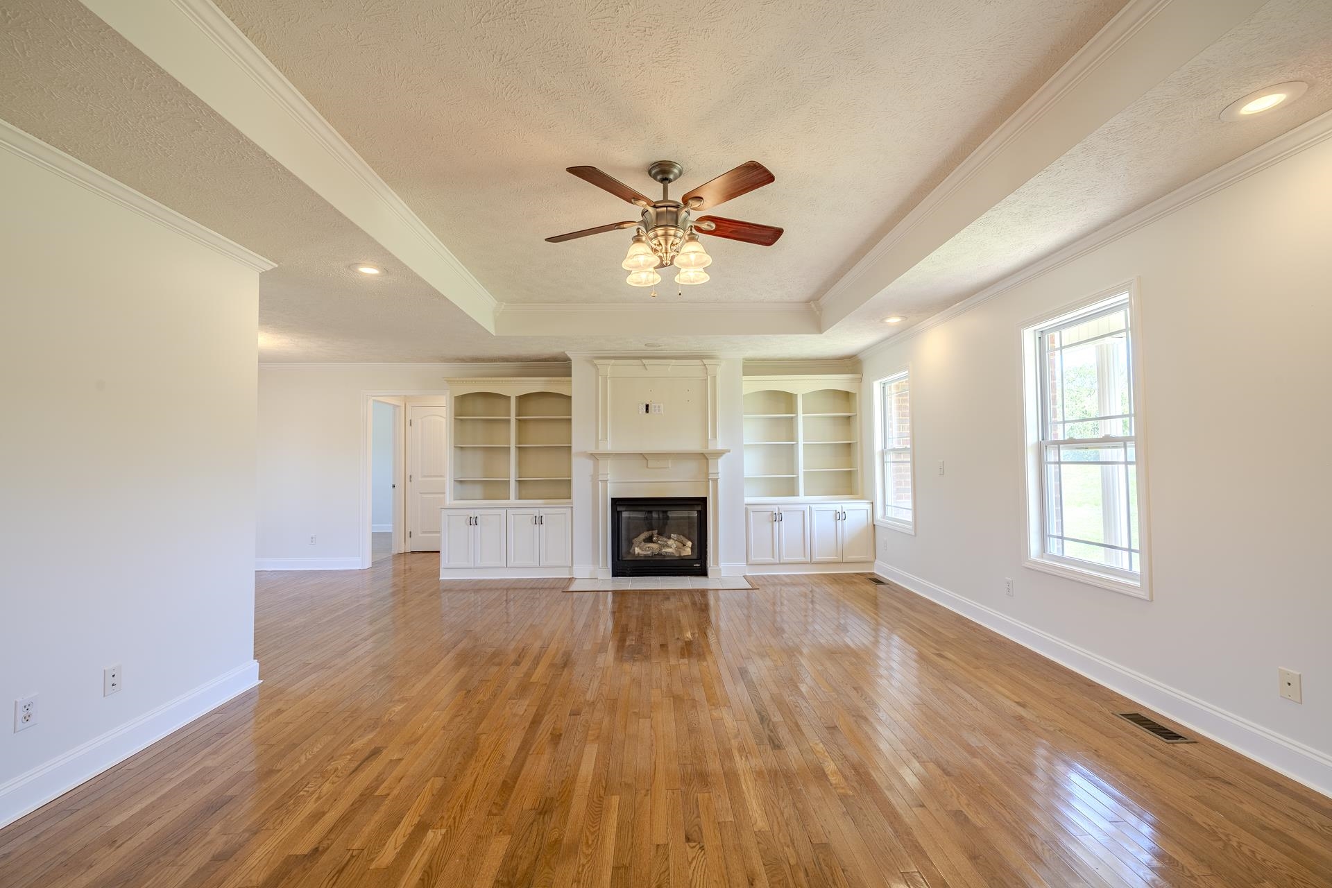 200 Boyd Road Adamsville, TN 38310 - Photo 6 of 26 a view of a livingroom with a fireplace a ceiling fan and windows