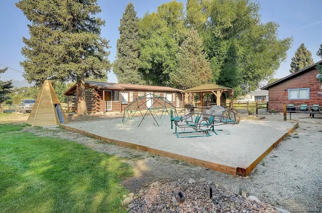 a view of a house with backyard and sitting area