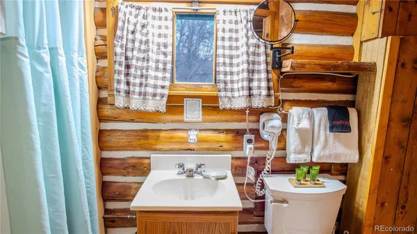 a bathroom with a sink a toilet and shower curtain