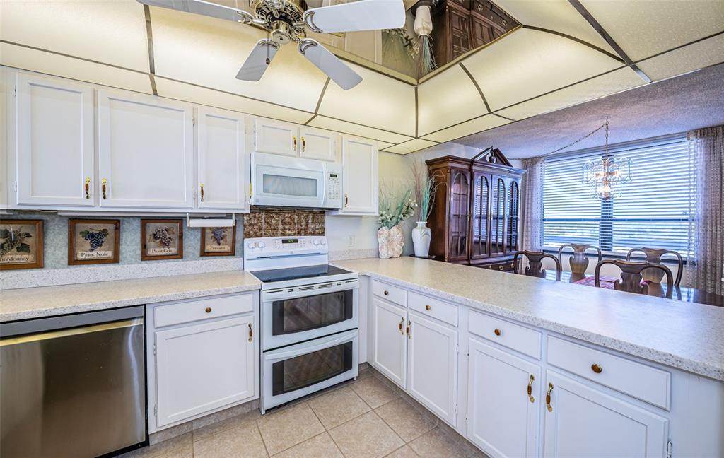 17940 Gulf Boulevard, Unit 7B Redington Shores, FL 33708 - Photo 29 of 58 a kitchen with stainless steel appliances granite countertop a sink a stove and cabinets