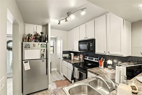 a kitchen with stainless steel appliances granite countertop a refrigerator stove and sink