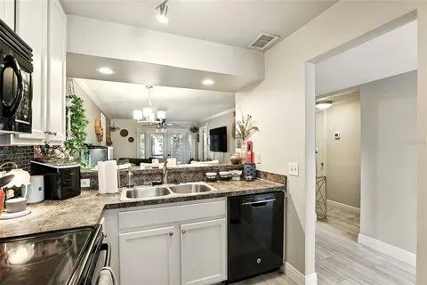 a bathroom with a granite countertop sink a mirror and a shower