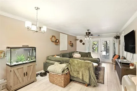 a living room with furniture a flat screen tv and floor to ceiling window