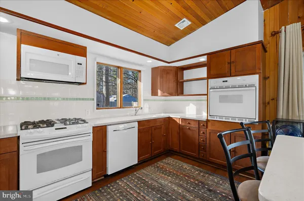 a bedroom with a bed and a flat tv screen on dresser