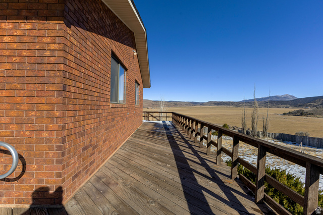 1208 East Tidwell Road Loa, UT 84747 - Photo 10 of 40 View of home's exterior with a deck with mountain view, brick siding, and a view of rural / pastoral area