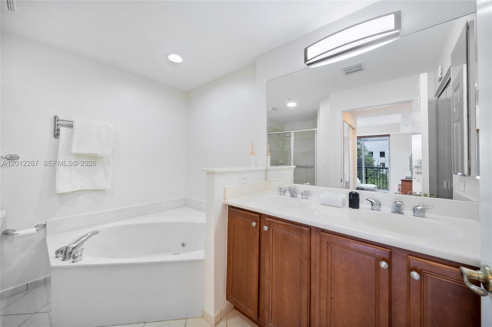 9021 Southwest 94th Street, Unit 310 Miami, FL 33176 - Photo 21 of 41 a bathroom with a bathtub a double vanity sink and mirror