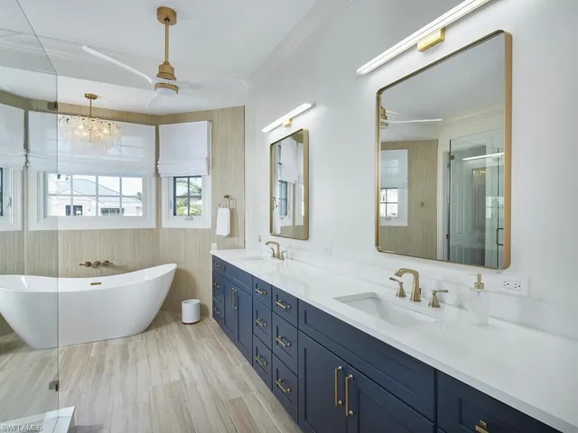 a spacious bathroom with a double vanity sink double mirror and bathtub