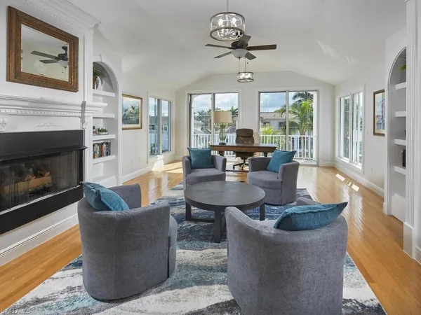 a living room with fireplace furniture and a large window