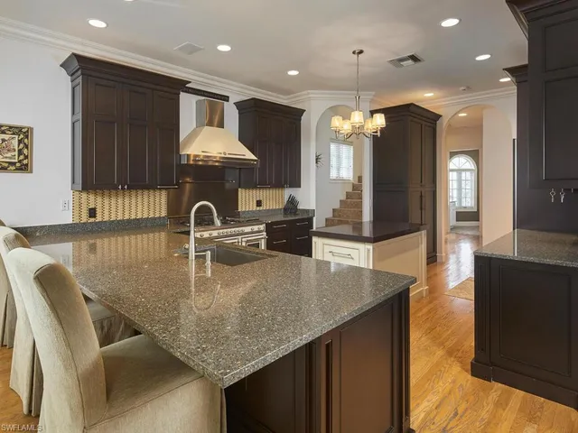 a kitchen with kitchen island a sink appliances and a counter top space