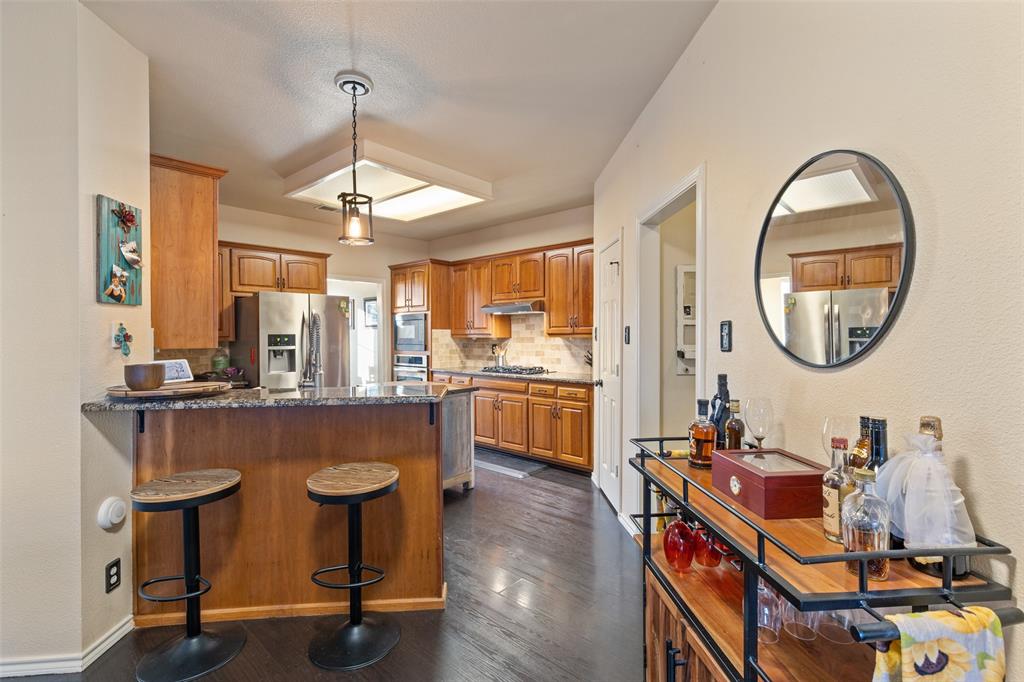 18212 Muir Circle Dallas, TX 75287 - Photo 6 of 13 a kitchen with a dining table chairs refrigerator and cabinets