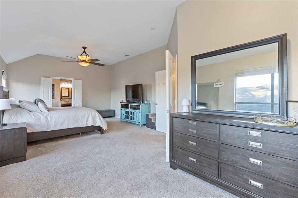 18212 Muir Circle Dallas, TX 75287 - Photo 7 of 13 a spacious bedroom with a large bed and a chandelier