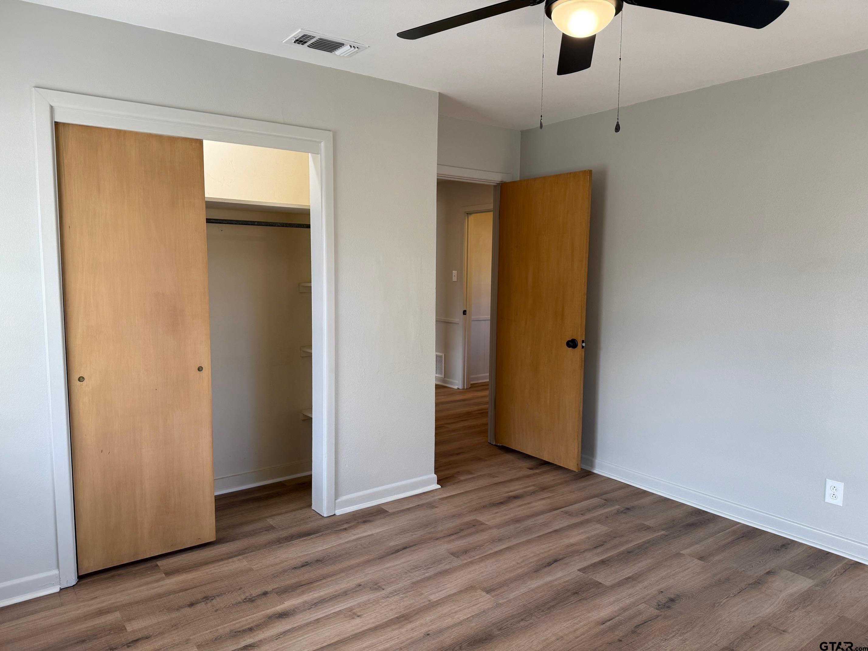 301 Ridgecrest Drive Tyler, TX 75701 - Photo 16 of 27 an empty room with wooden floor and a ceiling fan