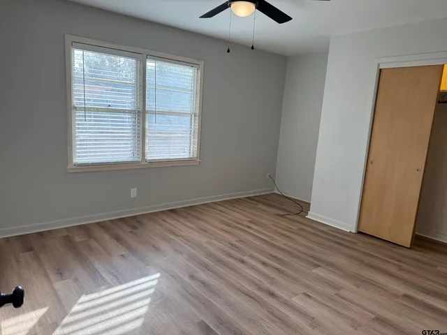 a view of empty room with wooden floor