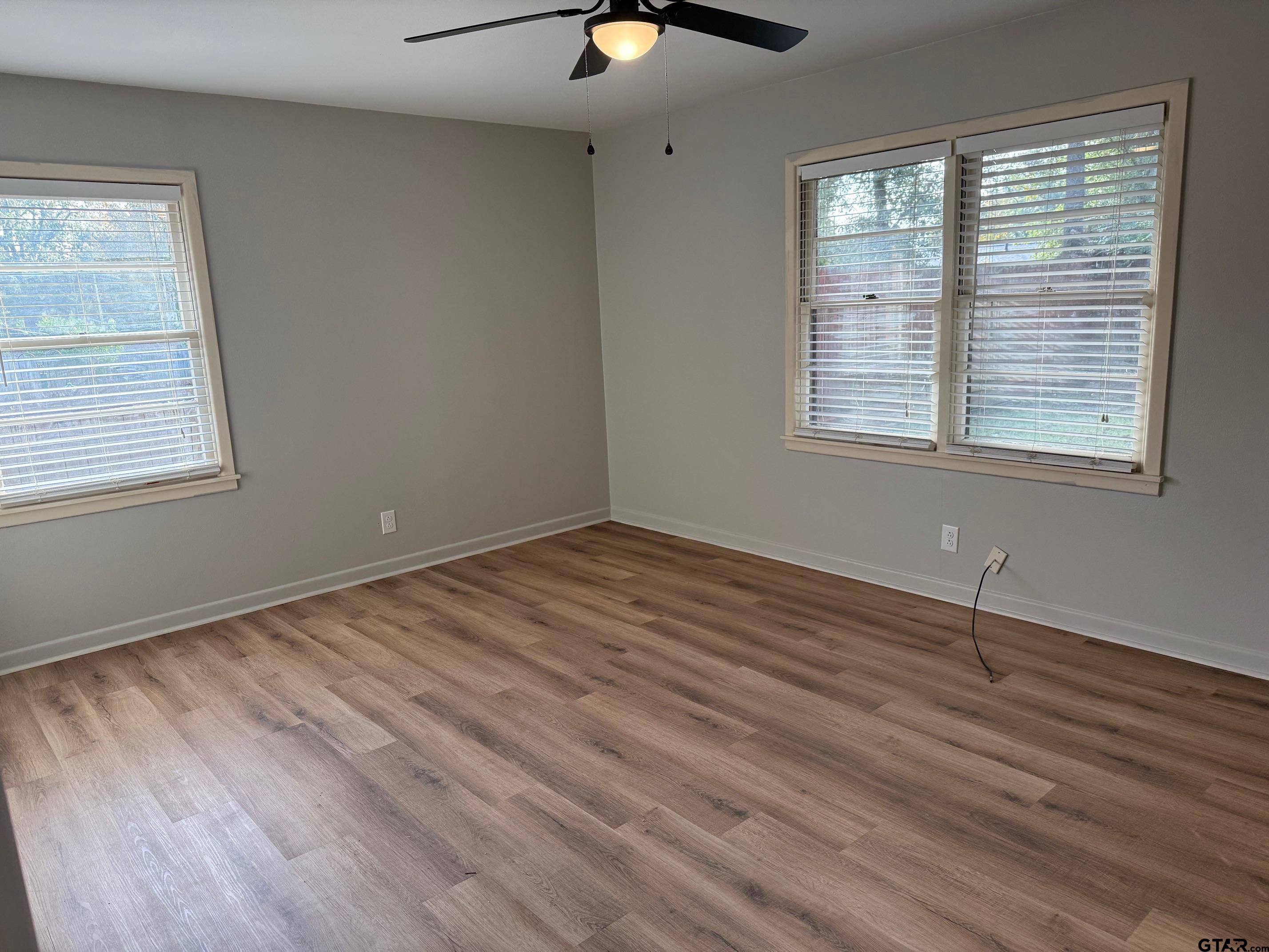 301 Ridgecrest Drive Tyler, TX 75701 - Photo 22 of 27 a view of an empty room with wooden floor and a window