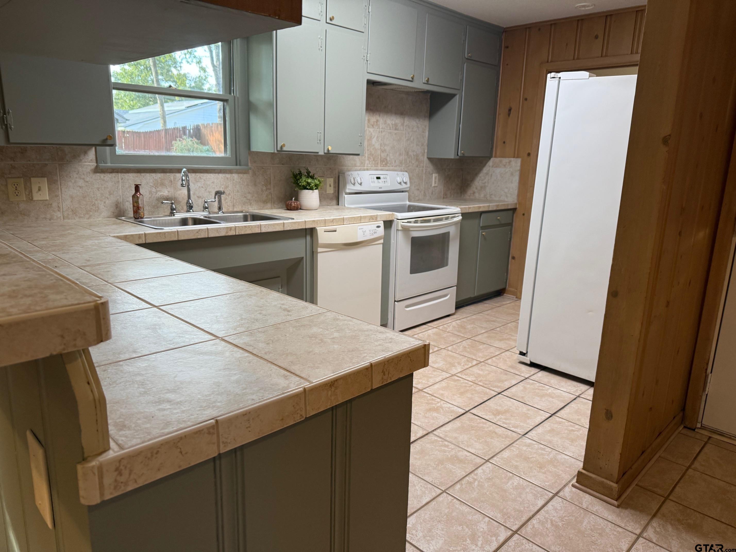 301 Ridgecrest Drive Tyler, TX 75701 - Photo 3 of 27 a kitchen with a sink a stove and a refrigerator